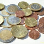 Pièces de monnaies de 1 et 2 euros avec aussi des pièces de 1, 2 et 5 centimes rassemblées en tas.